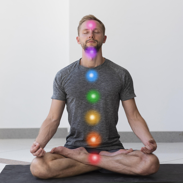 Workshop e Masterclass 20 immagine di uomo in posizione yoga del loto seduto a gambe incrociate, su cui sono apposti dei circoli di colori diversi in corrispondenza della posizione dei 7 chakra